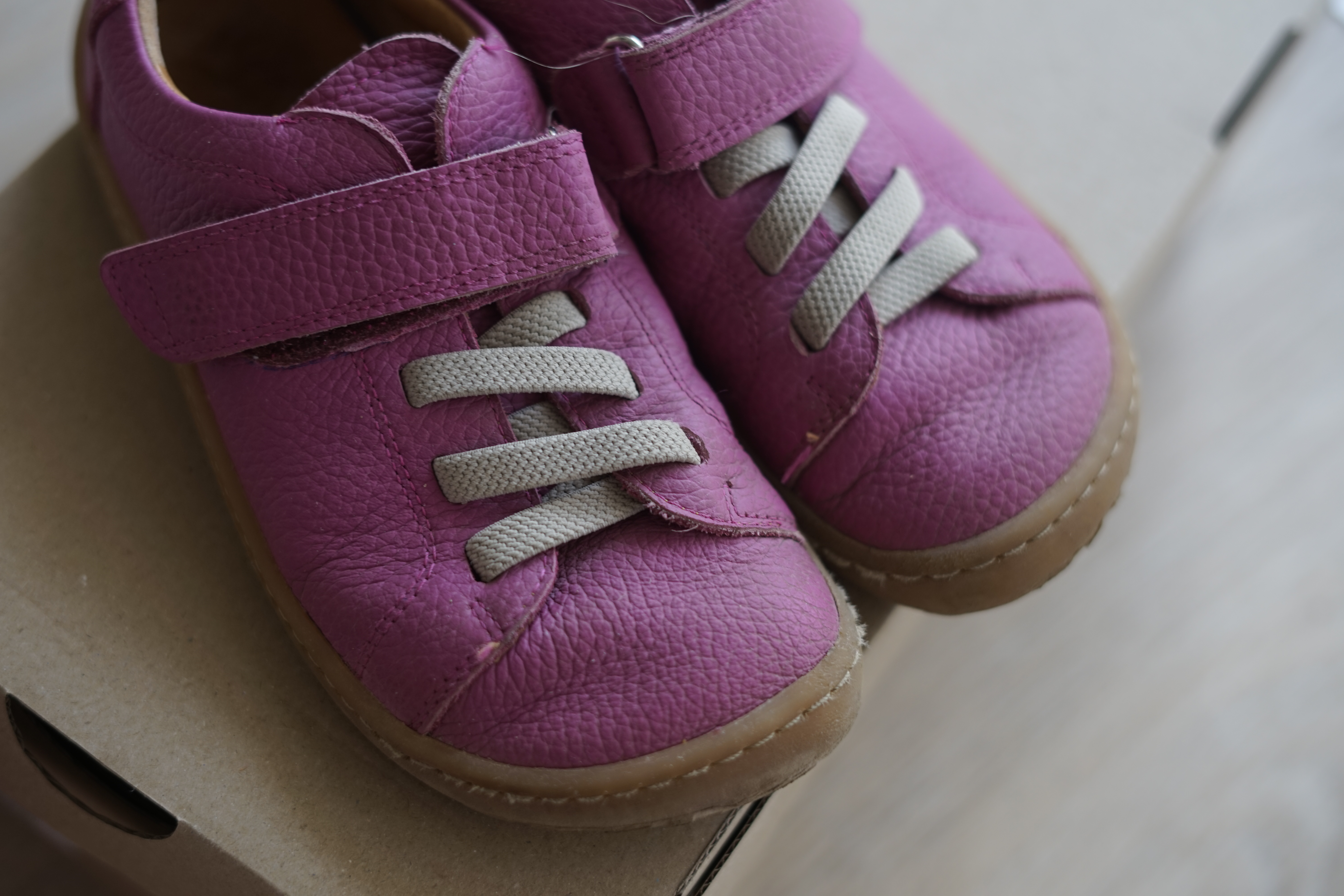 A pair of bright pink shoes is resting on top of a wooden box - <a href='https://www.vecteezy.com/free-photos/toddler-shoes'>Toddler Shoes Stock photos by Vecteezy</a>